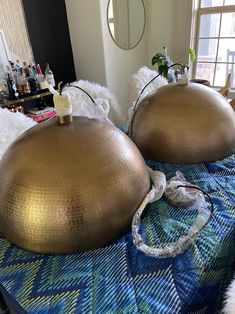 two large round metal objects sitting on top of a bed