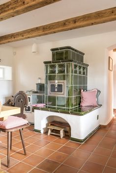 an old fashioned stove in the middle of a room with tile flooring and walls