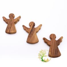 three wooden angel magnets sitting next to each other