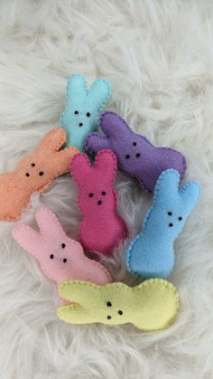 five small stuffed animals sitting on top of white fur