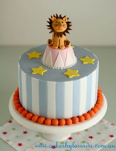 a birthday cake with a lion on top and stars around the edges, sitting on a table