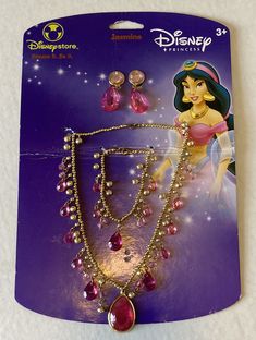 the disney princess necklace and earring set is shown in its package, with pink stones