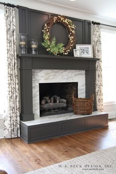 a living room with a fire place in the center and a wreath on top of it