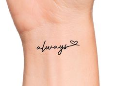 the word always written in cursive writing on a woman's left wrist