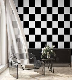 a black and white checkerboard wall in a living room with two chairs, a coffee table and flowers