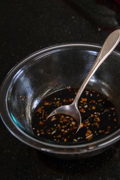 a spoon in a bowl filled with food