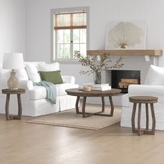 a living room filled with furniture and a fire place next to a white couch in front of a fireplace