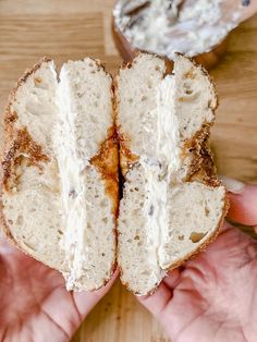 someone is holding a piece of bread with cream cheese on it and the rest of the sandwich has been cut in half