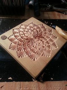 a wooden cutting board sitting on top of a table next to a pair of scissors