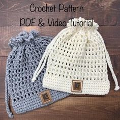 two crocheted bags sitting next to each other on a wooden floor, one is gray and the other is white