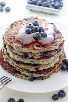 a stack of pancakes with blueberries and syrup on top