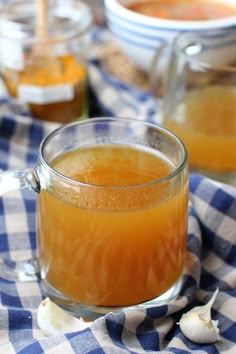 a glass mug filled with liquid sitting on top of a blue and white checkered table cloth