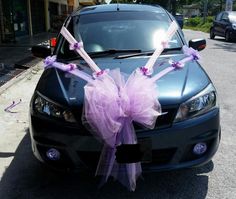 a car is decorated with purple ribbons and bows for someone to put on the hood