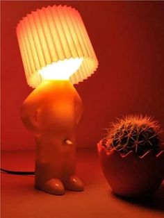 an elephant lamp sitting next to a cactus