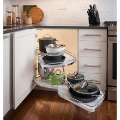 an open cabinet with pots and pans in it