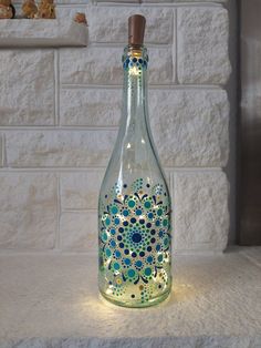 a glass bottle that is sitting on a counter with some lights in the shape of flowers