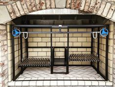 a brick oven with two metal racks and blue hoses on the door way to it