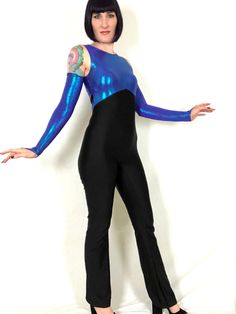 "Vintage 80s 90s Blue Purple Metallic Iridescent Lamé Dance Costume Jumpsuit! Features: - one piece stretchy spandex jumpsuit - top is composed of blue-purple iridescent metallic lamé - stretchy black spandex bottoms - back nylon zipper - 2 of these in stock; one comes with the matching gauntlet gloves, the other does not (price is reflected) Excellent condition! Bust: 30\"- 36\" Waist: 27\"+ Hips: 36\"- 40\" Rise: 23.5\" Inseam: 35\" Length: 57\"- 58\" Model is 5' 9\" and measures 33-27-39. Acc Disco Fitted Bodysuit For Costume Party, Disco Style Fitted Bodysuit For Costume Party, High Stretch Blue Bodysuit For Party, Full Length Stretch Unitard For Party, Blue Fitted Full-length Jumpsuits And Rompers, Blue Stretch Unitard For Costume Party, Blue Dance Bodysuit, Blue Fitted Dancewear Bodysuit, Blue Dancewear Bodysuit For Dance