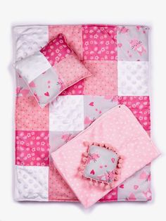 a pink and white patchwork quilt with hearts on it's side, along with two pillows