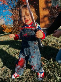 a young child holding a baseball bat in the grass