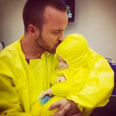 a man in yellow raincoat holding a baby