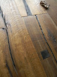 a close up of a wooden floor with peeling paint on the top and bottom part