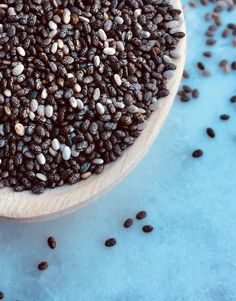 a wooden spoon filled with black and white seeds