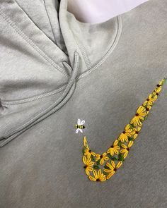 a close up of a person wearing a sweatshirt with sunflowers and bees on it