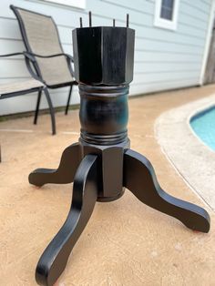 an outdoor table and chair with a pool in the background