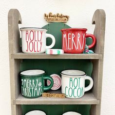 christmas mugs are sitting on top of a shelf