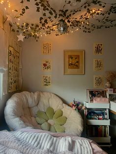 a bedroom with lights strung from the ceiling and pictures on the wall above it, along with a bean bag chair