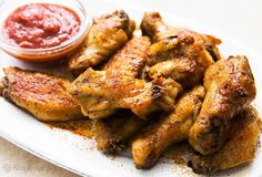 chicken wings on a plate with ketchup and sauce