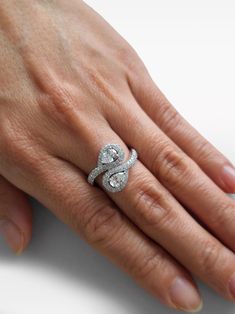 a woman's hand with a diamond ring on top of her left hand,