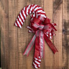 a red and white candy cane wreath on a wooden fence