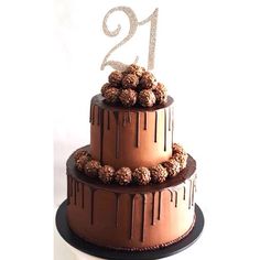 a three tiered cake with chocolate frosting and nuts on top is decorated with the number twenty two