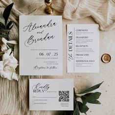 the wedding stationery is laid out next to some flowers