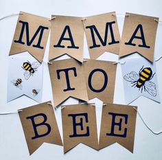 several pieces of paper with the words mama to bee on them hanging from clothes pins