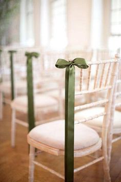 white chairs with green ribbons tied to them