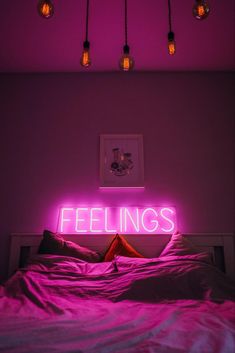 there is a neon sign that says feelings on the wall next to a bed with pink sheets