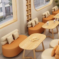 a room filled with lots of orange and white furniture next to a large window on the wall