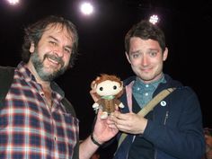 two men standing next to each other with stuffed animals in their hands and smiling at the camera