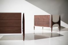 two pieces of furniture sitting next to each other on a white floor in front of a wall