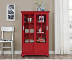 a red bookcase with glass doors in a living room