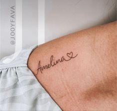 the back of a woman's shoulder with an arm tattoo that reads, amelina