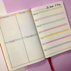 an open planner book sitting on top of a pink table