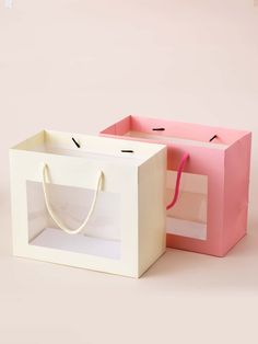 two white and pink paper bags with handles