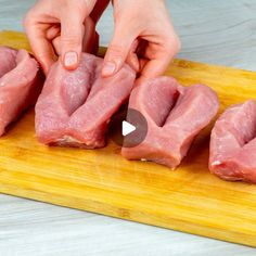 someone is cutting up raw meat on a wooden board