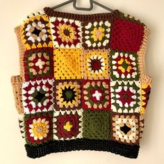 a crocheted sweater hanging on a wall