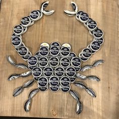 a crab made out of buttons sitting on top of a wooden table