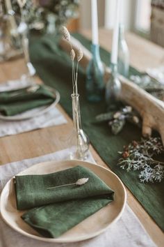 the table is set with green napkins and place settings